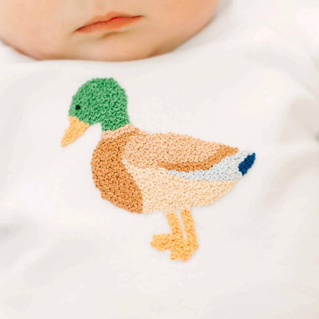 That Store white baby sweatshirt featuring a detailed hand-embroidered mallard duck appliqué in natural tones.
