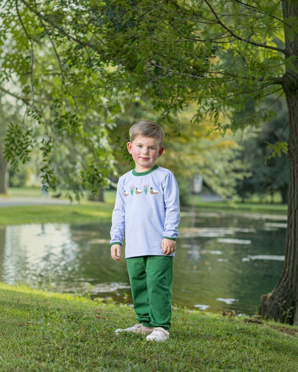 That Store boys blue stripe long sleeve shirt with mallard appliques and green jogger pants in a park setting