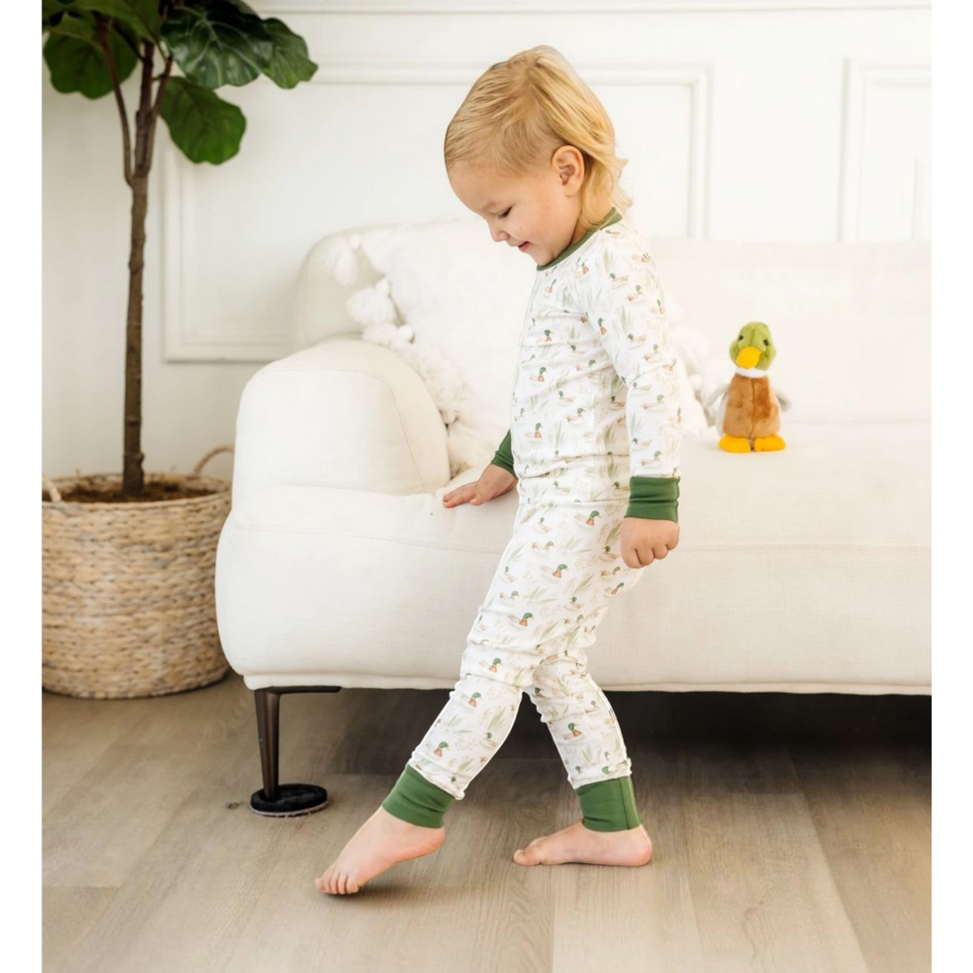 Toddler wearing That Store Mallard's Pond green long sleeve pajamas made of soft Peruvian Pima cotton in a bright room.