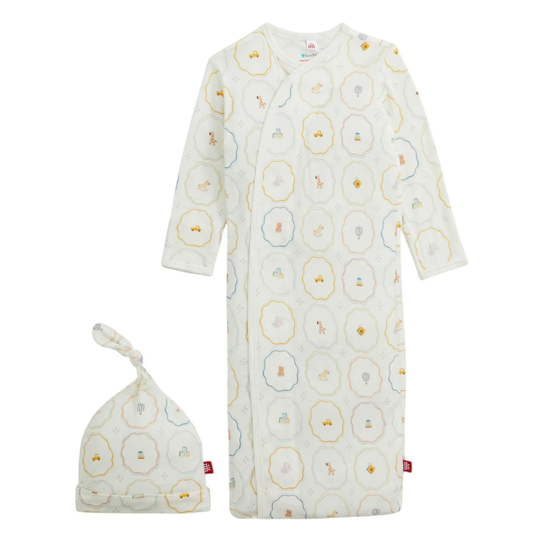 That Store Nursery Magic modal magnetic gown and matching hat set with a white background and colorful toy print.