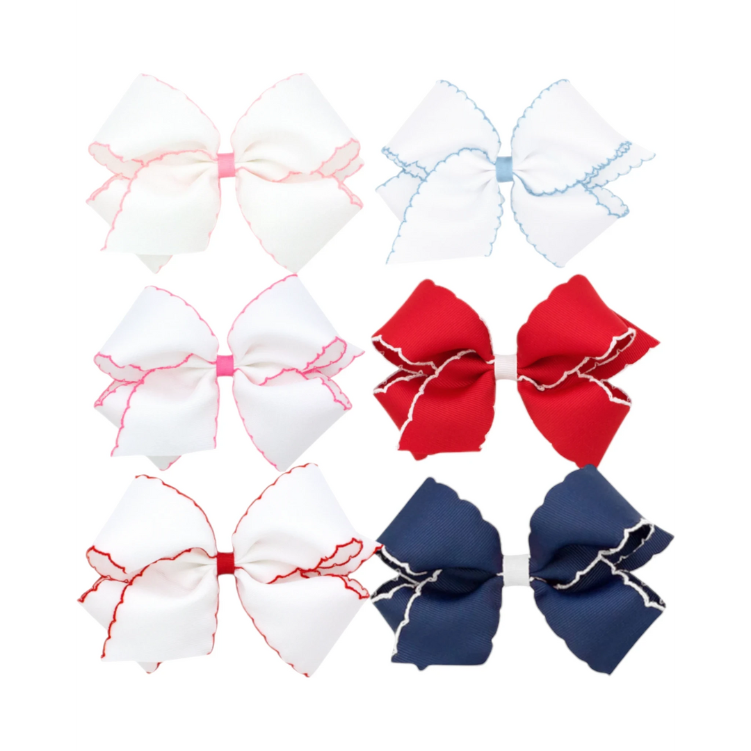 That Store Moonstitch grosgrain hair bows in various colors with contrasting scalloped edges and no-slip clips.