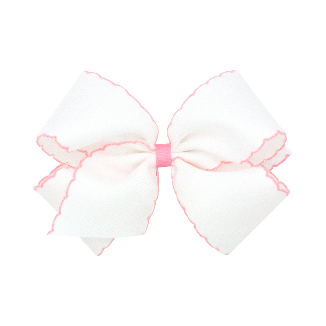 That Store Moonstitch medium white grosgrain hair bow with pink contrasting scalloped edges and a pink center wrap.
