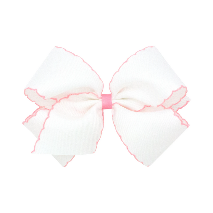 That Store Moonstitch medium white grosgrain hair bow with pink contrasting scalloped edges and a pink center wrap.