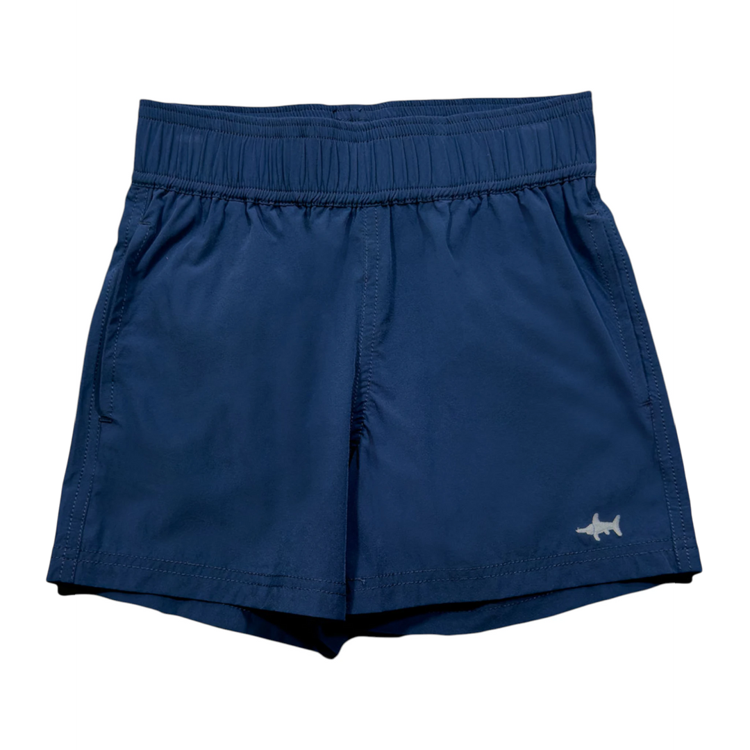 That Store navy boys performance shorts with elastic waistband, quick-dry stretch fabric, and small shark logo detail.