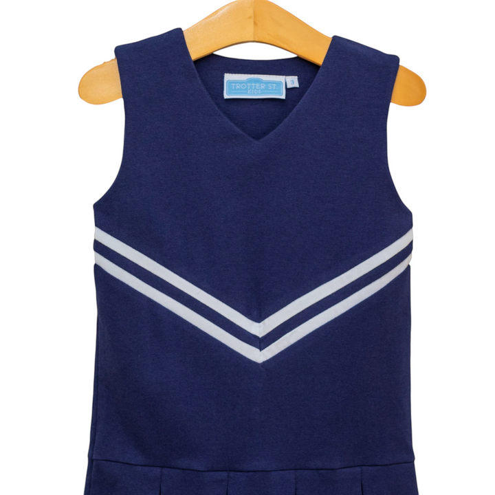 That Store navy cheer uniform dress with white chevron stripes on a wooden hanger