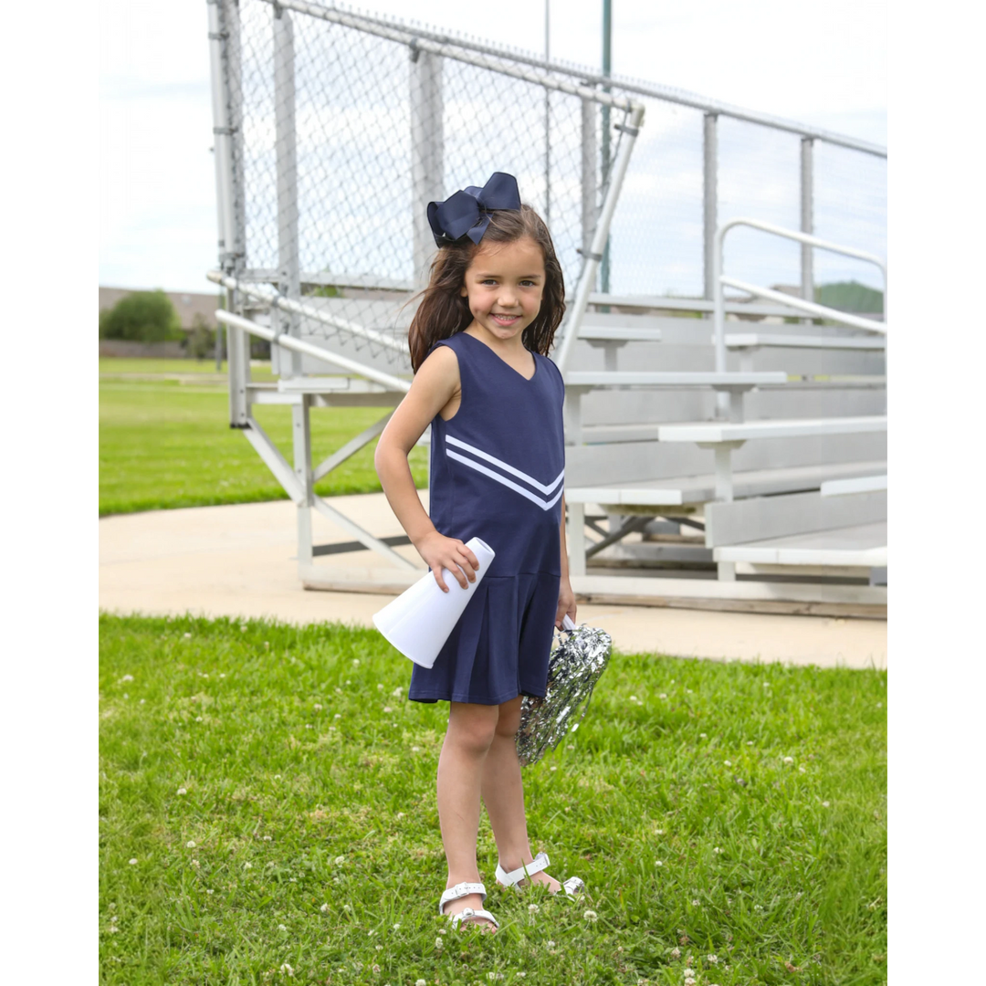 That Store navy cheer uniform dress with white chevron stripes worn by a girl holding a megaphone and pom-poms
