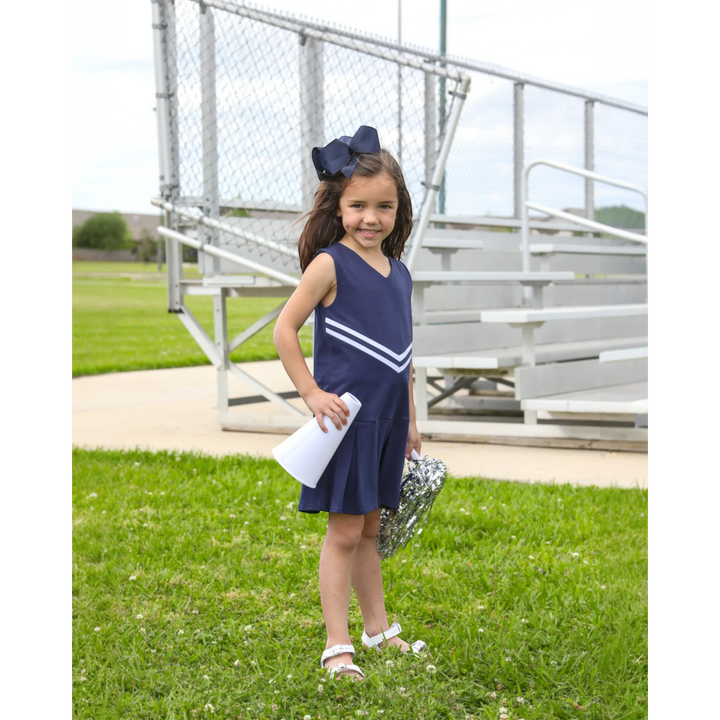 That Store navy cheer uniform dress with white chevron stripes worn by a girl holding a megaphone and pom-poms