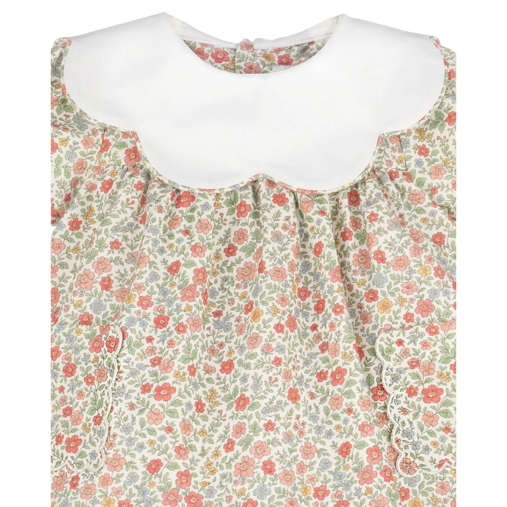 That Store vintage orange floral dress with a white scalloped collar and delicate ruffled pocket detailing.