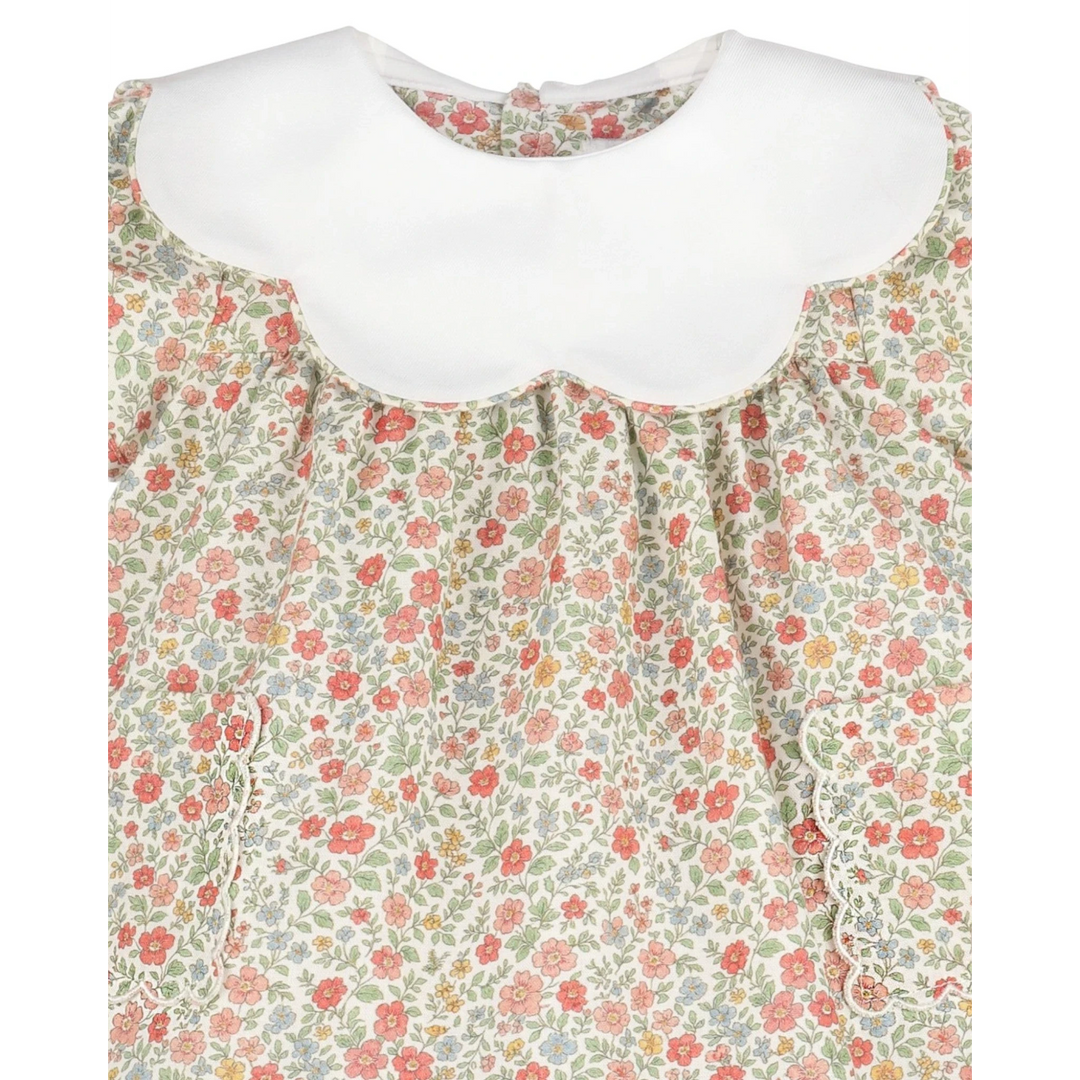 That Store vintage orange floral dress with a white scalloped collar and delicate ruffled pocket detailing.