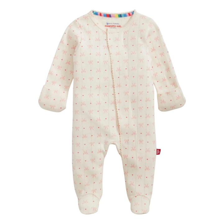That Store organic cotton pointelle baby footie sleeper in cream with a delicate red heart and bow pattern.