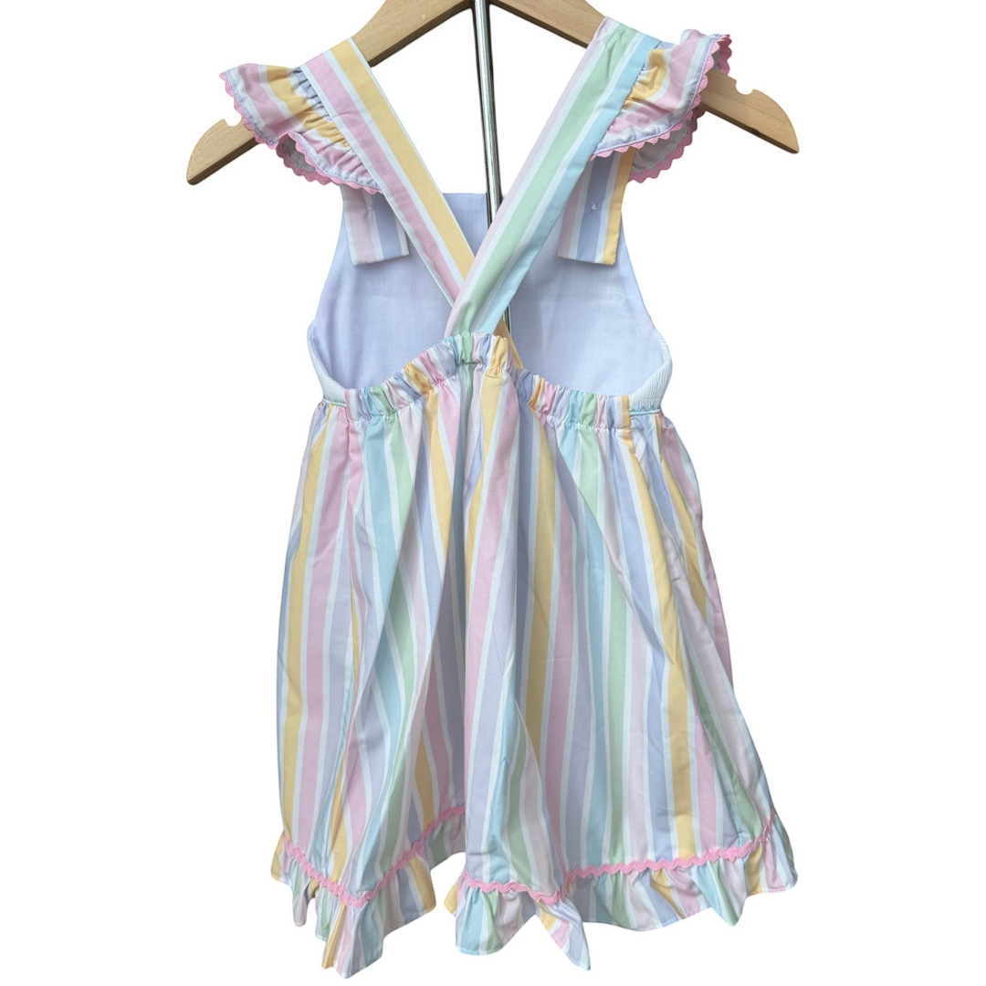 That Store smocked dress featuring pastel vertical stripes, ruffled shoulder straps, and pink trim on a wooden hanger.