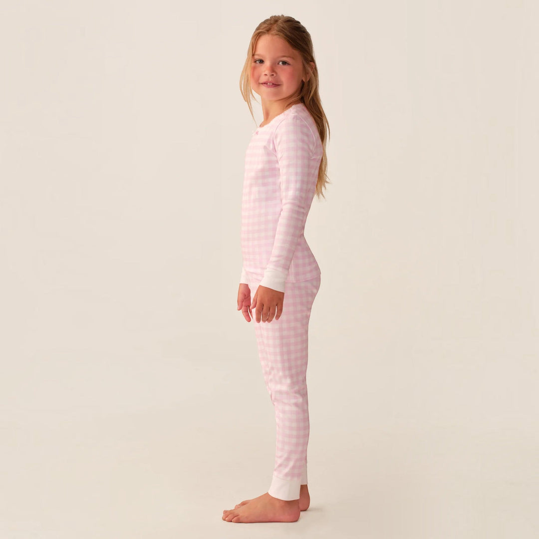 Young girl wearing a That Store pink gingham long sleeve Pima cotton pajama set with a snug fit
