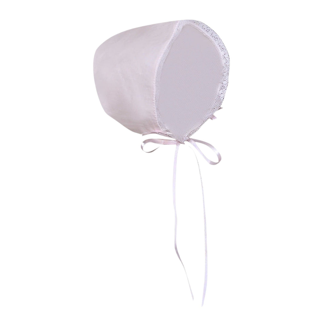 That Store blush pink baby bonnet with delicate white lace trim and ribbon ties for a vintage-inspired look