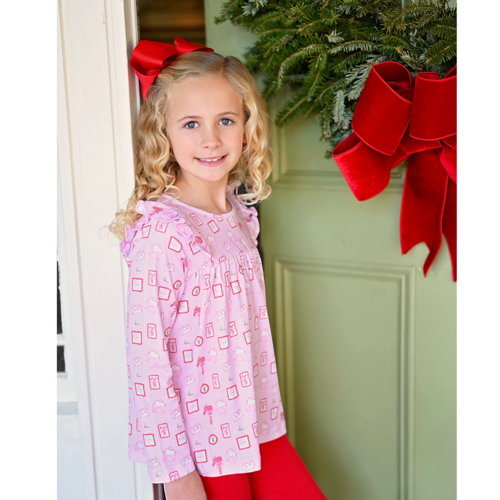 That Store Letters to Santa pink knit swing top and red leggings set worn by a girl with a red hair bow