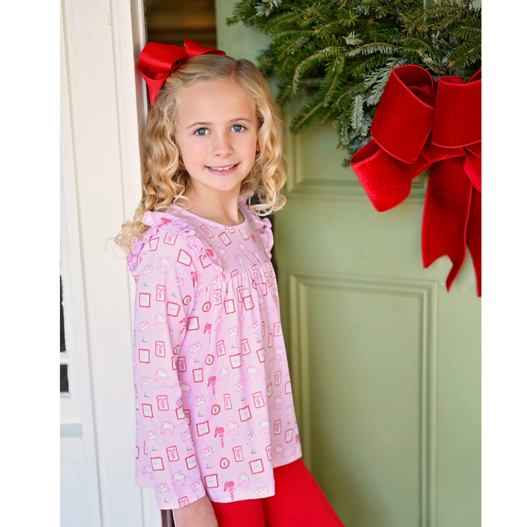 That Store Letters to Santa pink knit swing top and red leggings set worn by a girl with a red hair bow