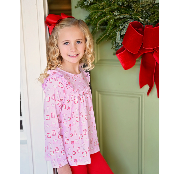 That Store Letters to Santa pink knit swing top and red leggings set worn by a girl with a red hair bow