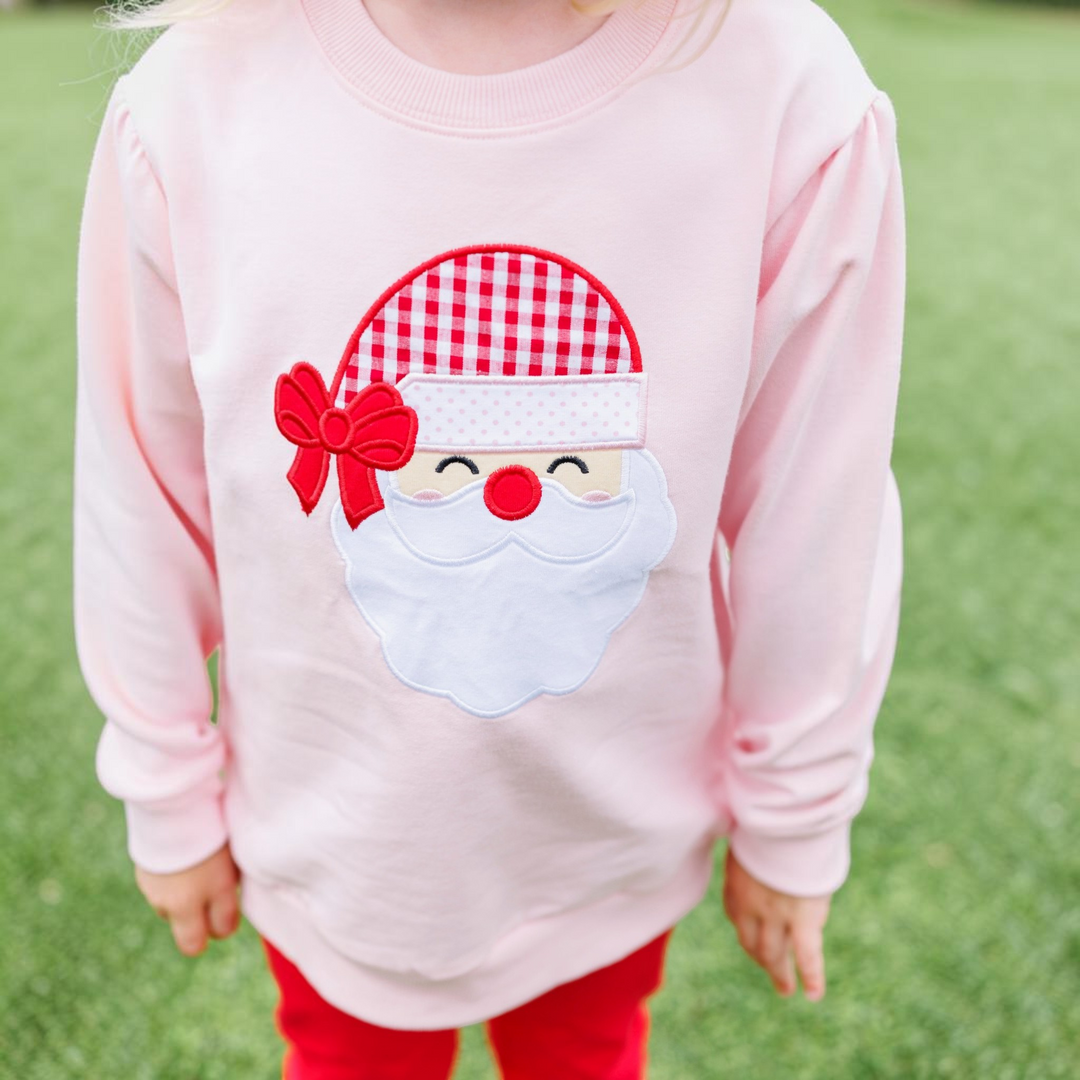 That Store girls pink French terry pullover featuring a festive Santa applique with a red gingham hat and bow.