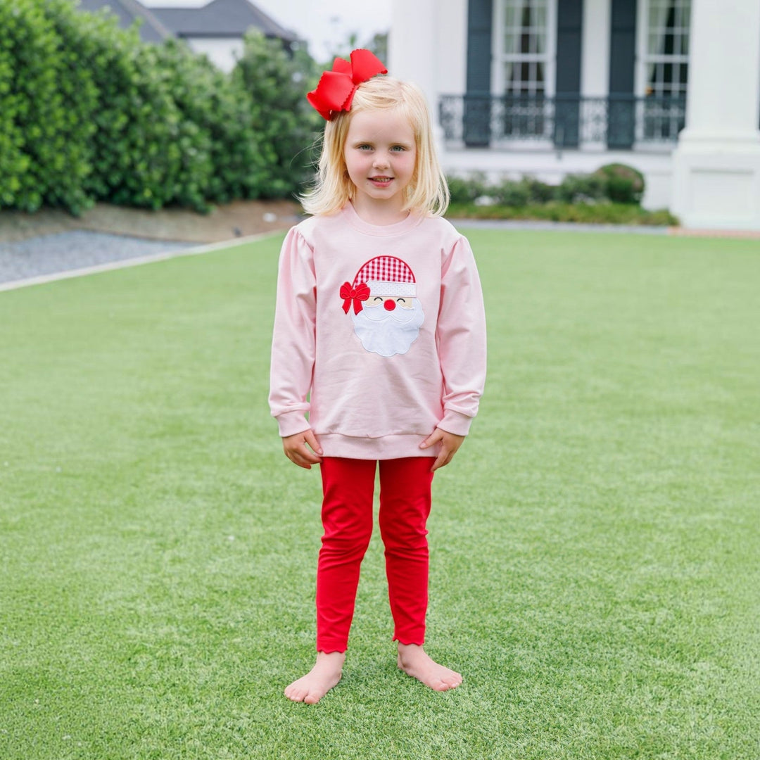 That Store pink French terry pullover with Santa applique worn by a young girl with a large red hair bow