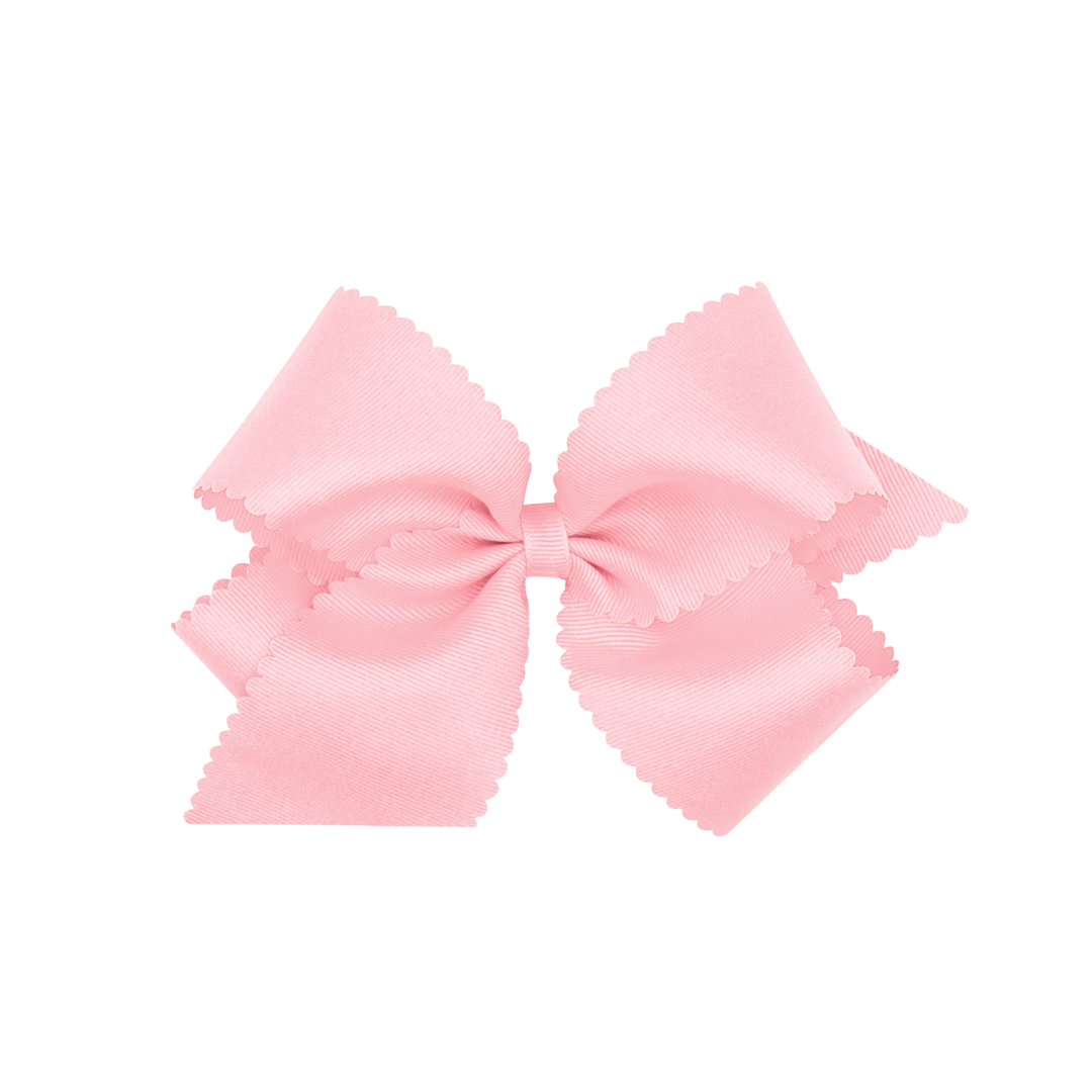 That Store light pink grosgrain hair bow for girls featuring a decorative scalloped edge and a secure hair clip.