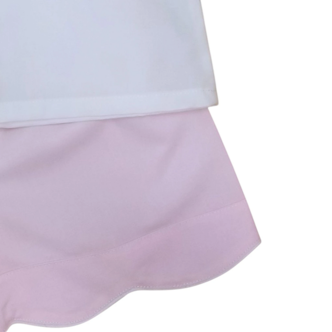 That Store girls pink scalloped shorts paired with a white top featuring delicate cross embroidery for spring