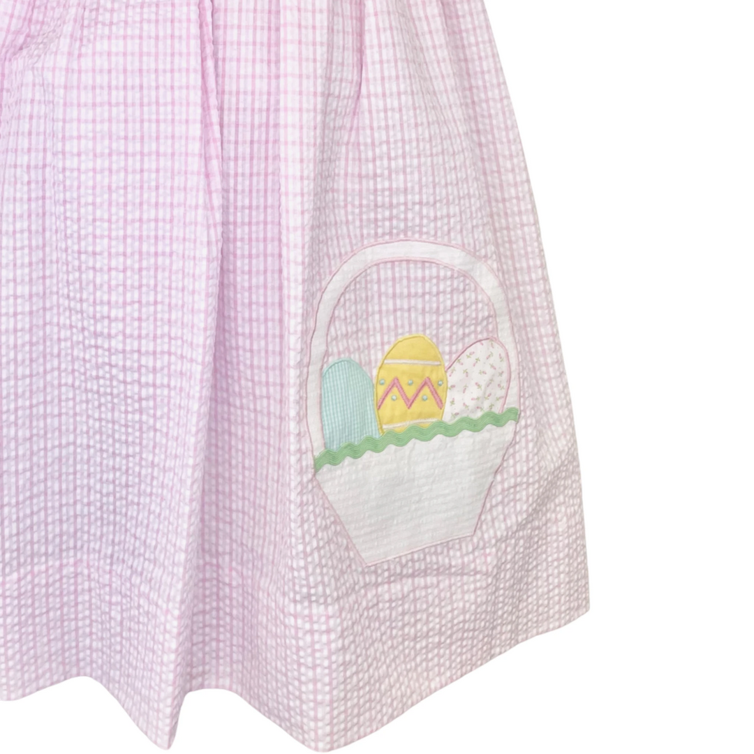 That Store girls pink seersucker plaid dress featuring an Easter basket applique with colorful patterned eggs