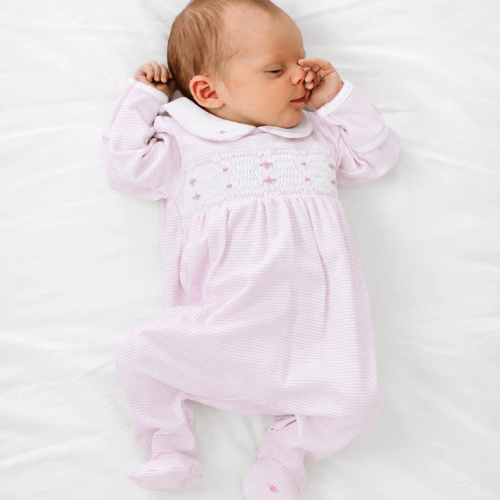 Newborn baby wearing a That Store pink micro-stripe footie with hand-smocked chest, rosebud embroidery, and Peter Pan collar