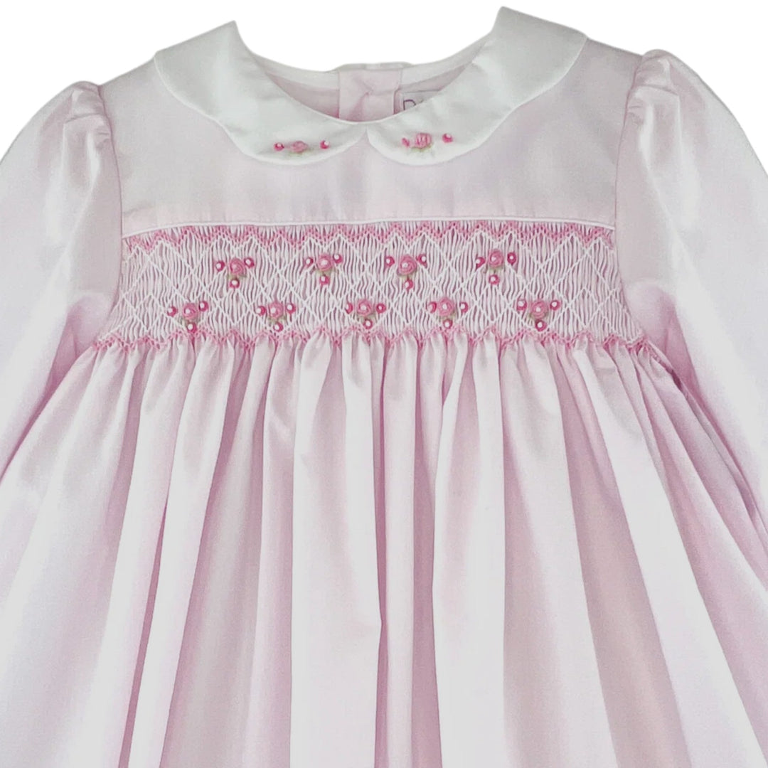 That Store girls pink dress with corded smocking, embroidered rosette details, and a white scalloped collar.