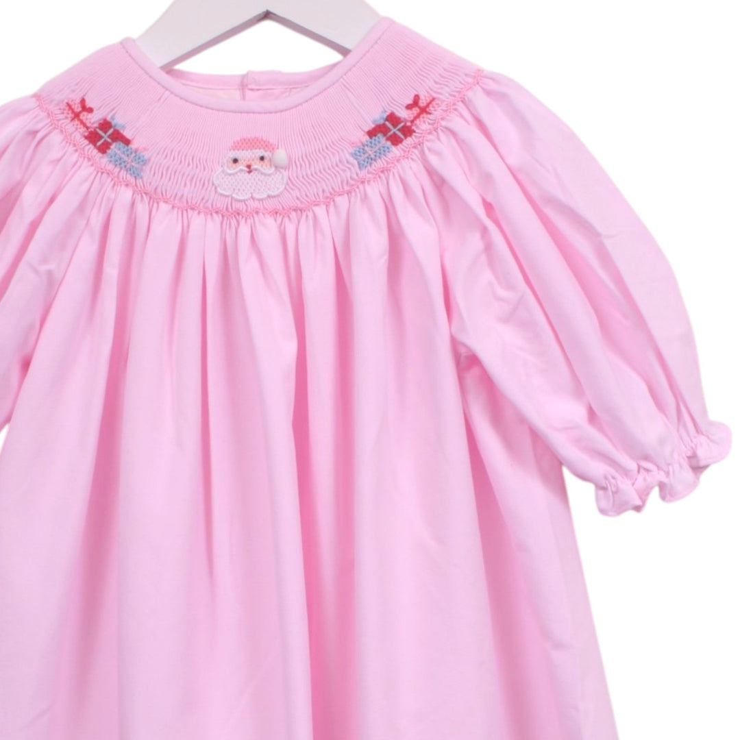 That Store pink bishop dress with smocked neckline featuring embroidered Santa Claus and gift boxes for girls.