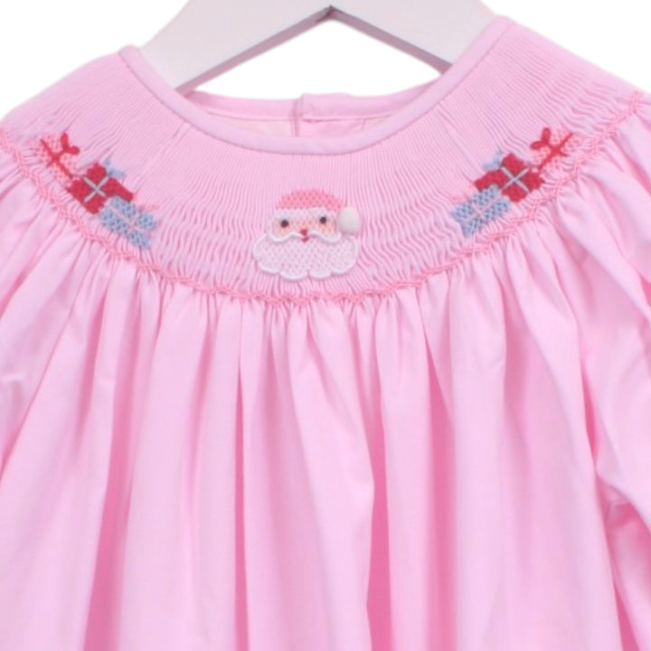 That Store pink bishop dress featuring a smocked neckline with embroidered Santa Claus and festive gift boxes.
