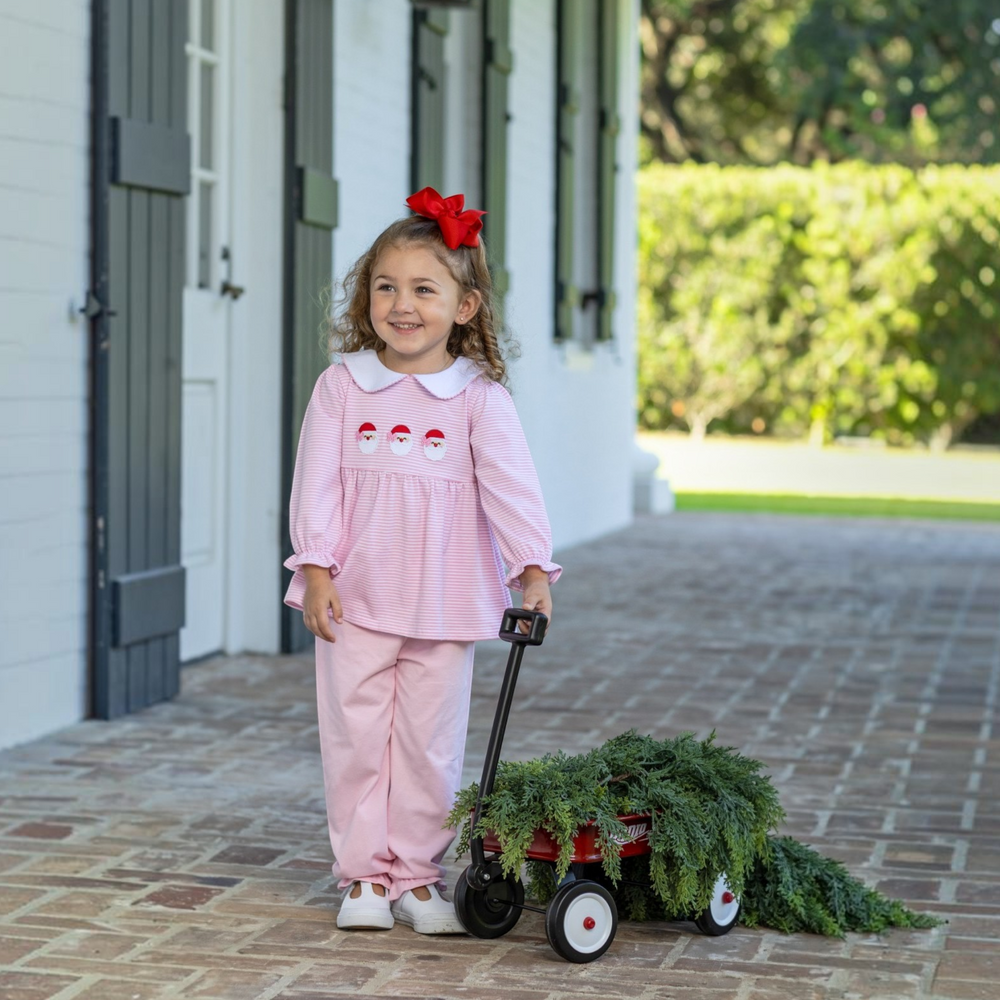 That Store girls pink stripe bloomer set with Santa trio applique worn by a smiling toddler with a red hair bow