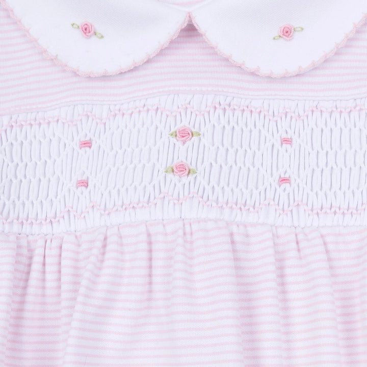 That Store pink micro-stripe baby footie with hand-smocked chest, embroidered rosebuds, and a white Peter Pan collar.