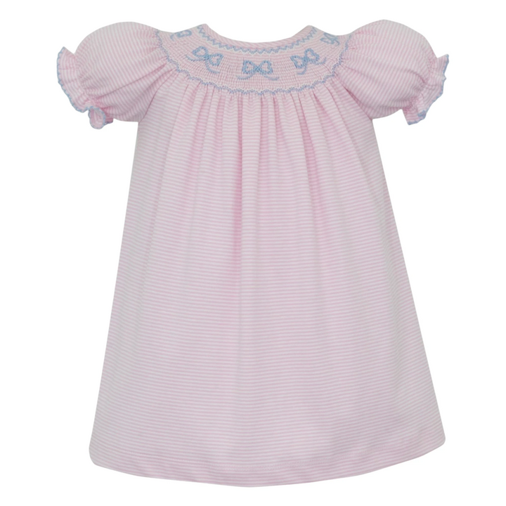 That Store pink striped cotton bishop dress with hand-smocked blue bows and puff sleeves for a classic look.