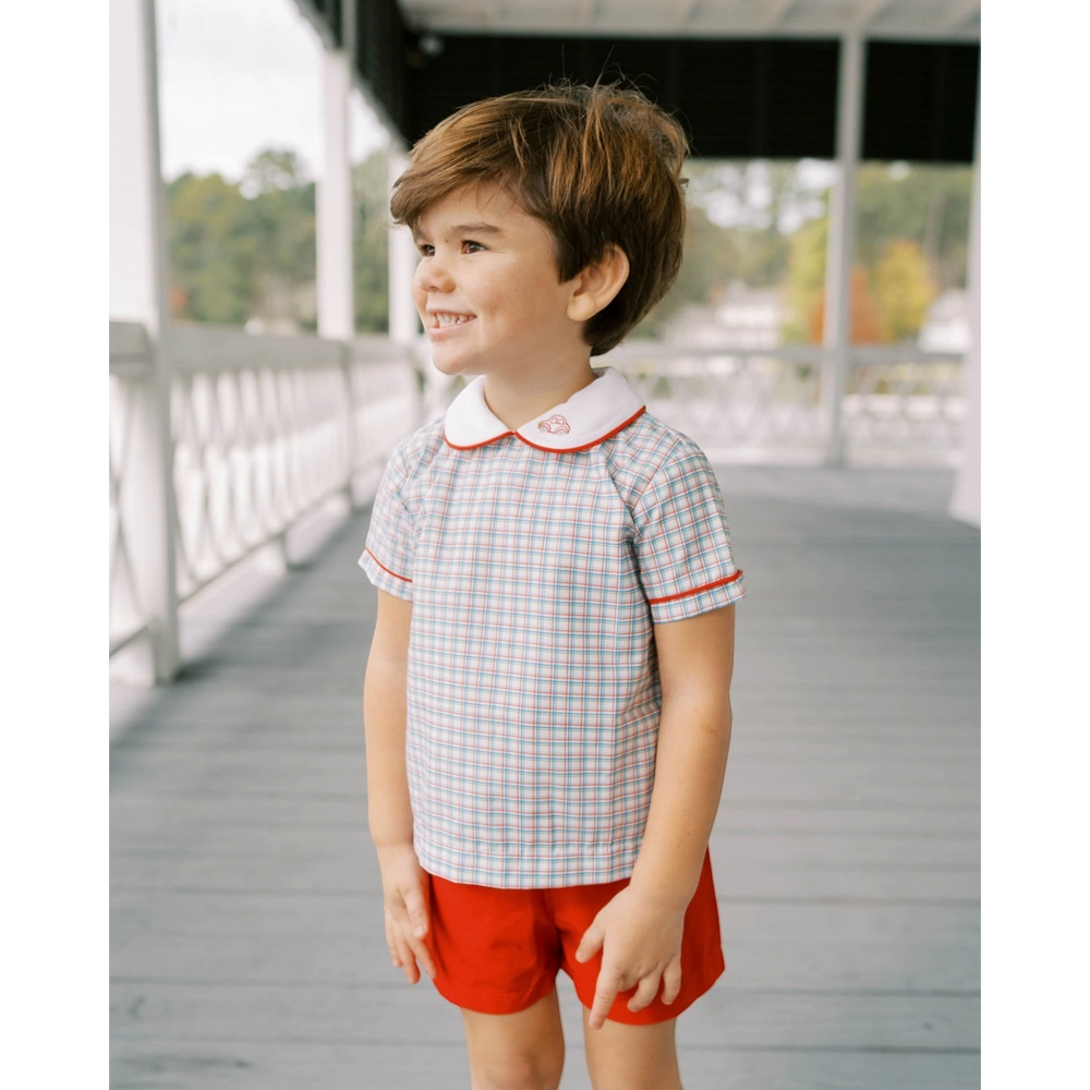 That Store toddler boy wearing a Raleigh Red primary plaid Sibley shirt with car embroidery and matching red shorts.