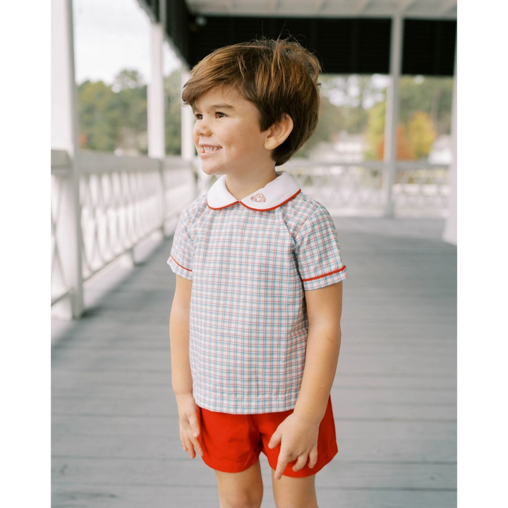 That Store toddler boy wearing a Raleigh Red primary plaid Sibley shirt with car embroidery and matching red shorts.