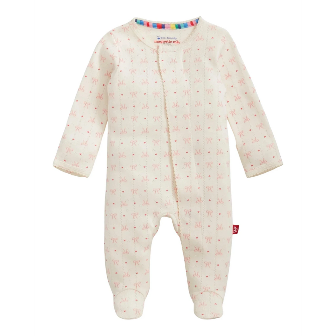 That Store organic cotton pointelle magnetic footie sleeper in cream with a delicate pink heart and bow print.