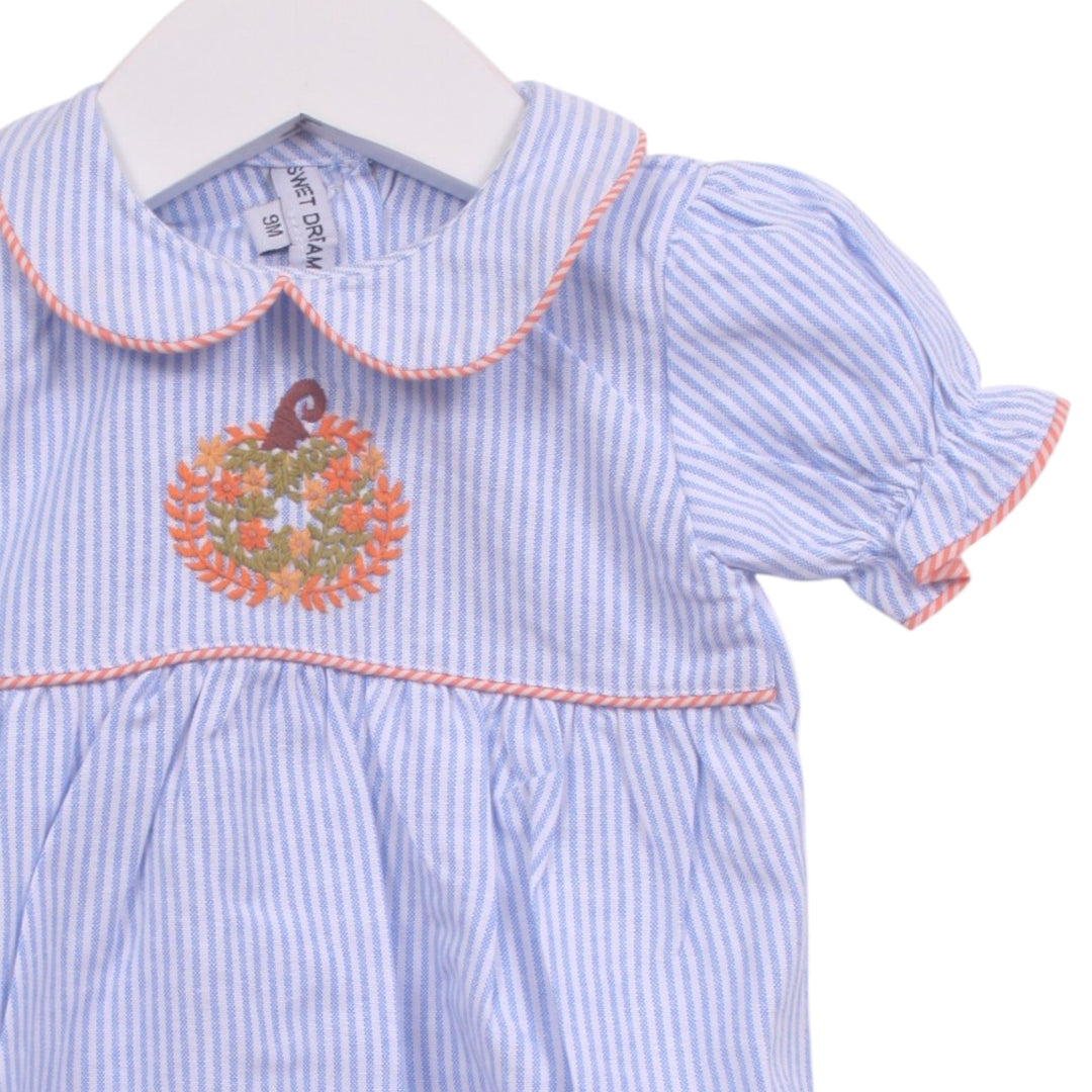 That Store blue and white pinstripe dress with pumpkin embroidery, Peter Pan collar, and orange piping detail.