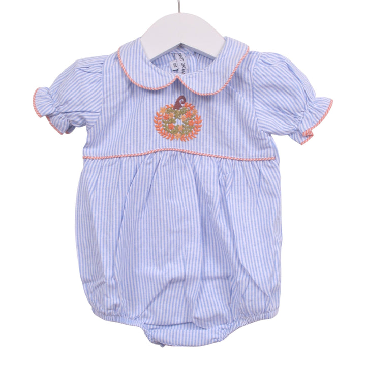 That Store girls blue and white striped bubble romper featuring a pumpkin embroidery and pink piping trim.