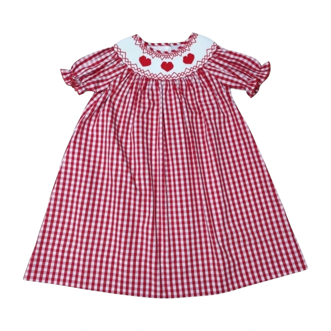 That Store red gingham dress for girls featuring a white collar with smocked red hearts and short puff sleeves.