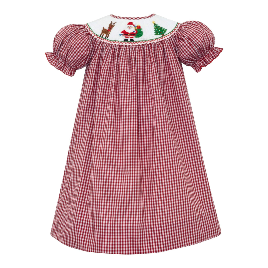 That Store girls red gingham bishop dress featuring a white smocked neckline with Santa, reindeer, and tree motifs.