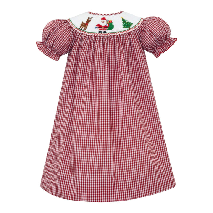 That Store girls red gingham bishop dress featuring a white smocked neckline with Santa, reindeer, and tree motifs.