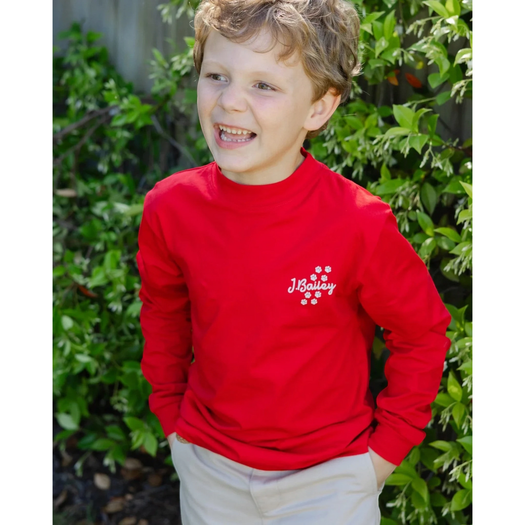That Store red long sleeve cotton tee for boys featuring a small white logo on the chest, worn by a young boy.