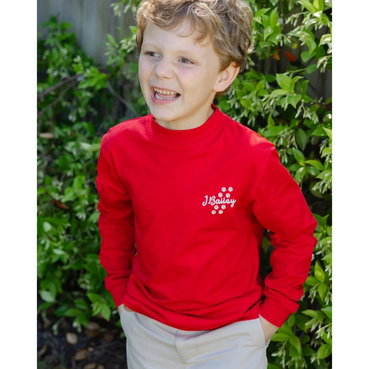 That Store red long sleeve cotton tee for boys featuring a small white logo on the chest, worn by a young boy.
