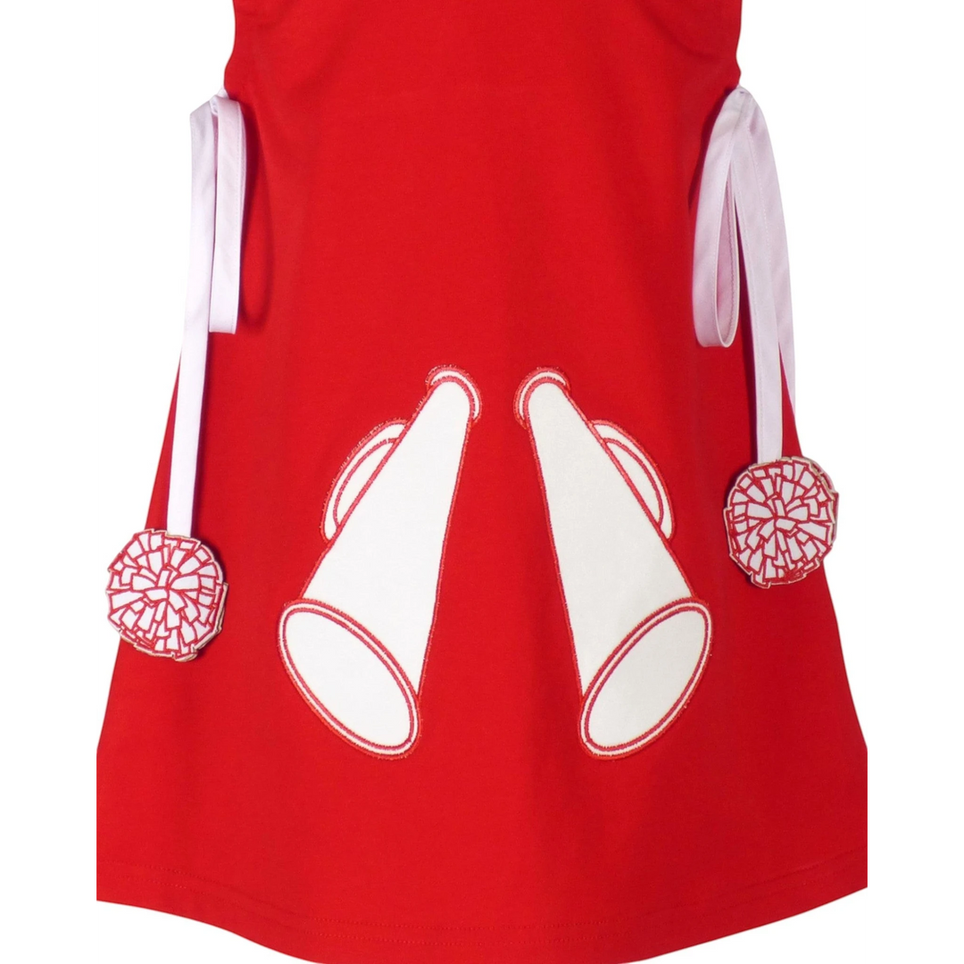 That Store red cotton jumper dress featuring white megaphone appliques and pom-pom trimmed ties for girls.