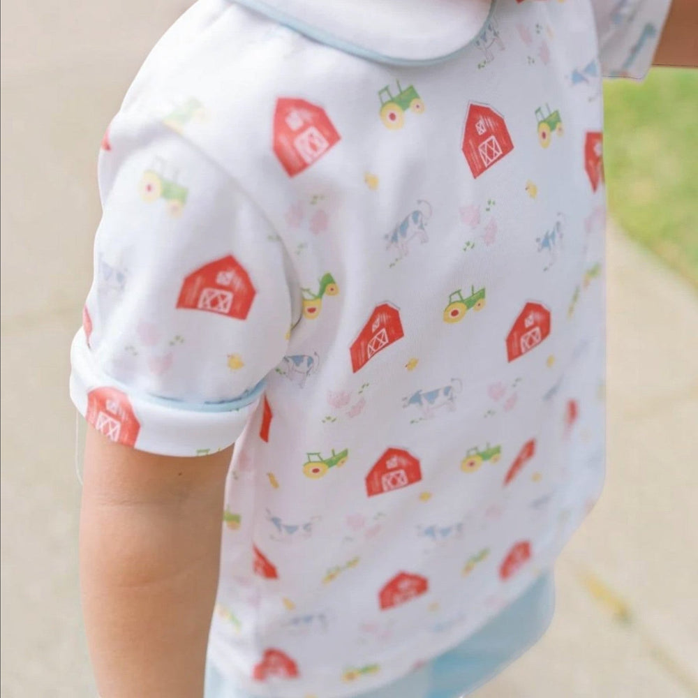 That Store Sibley boys pant set featuring a white top with a red barn and tractor print and blue knit pants