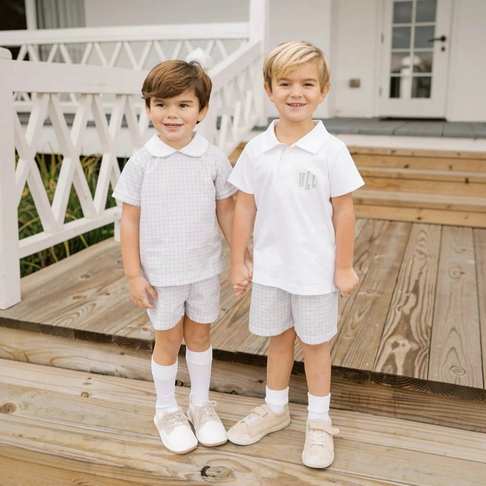 Two boys wearing That Store Sibley short sets in countryside plaid with white collared shirts and matching shorts.