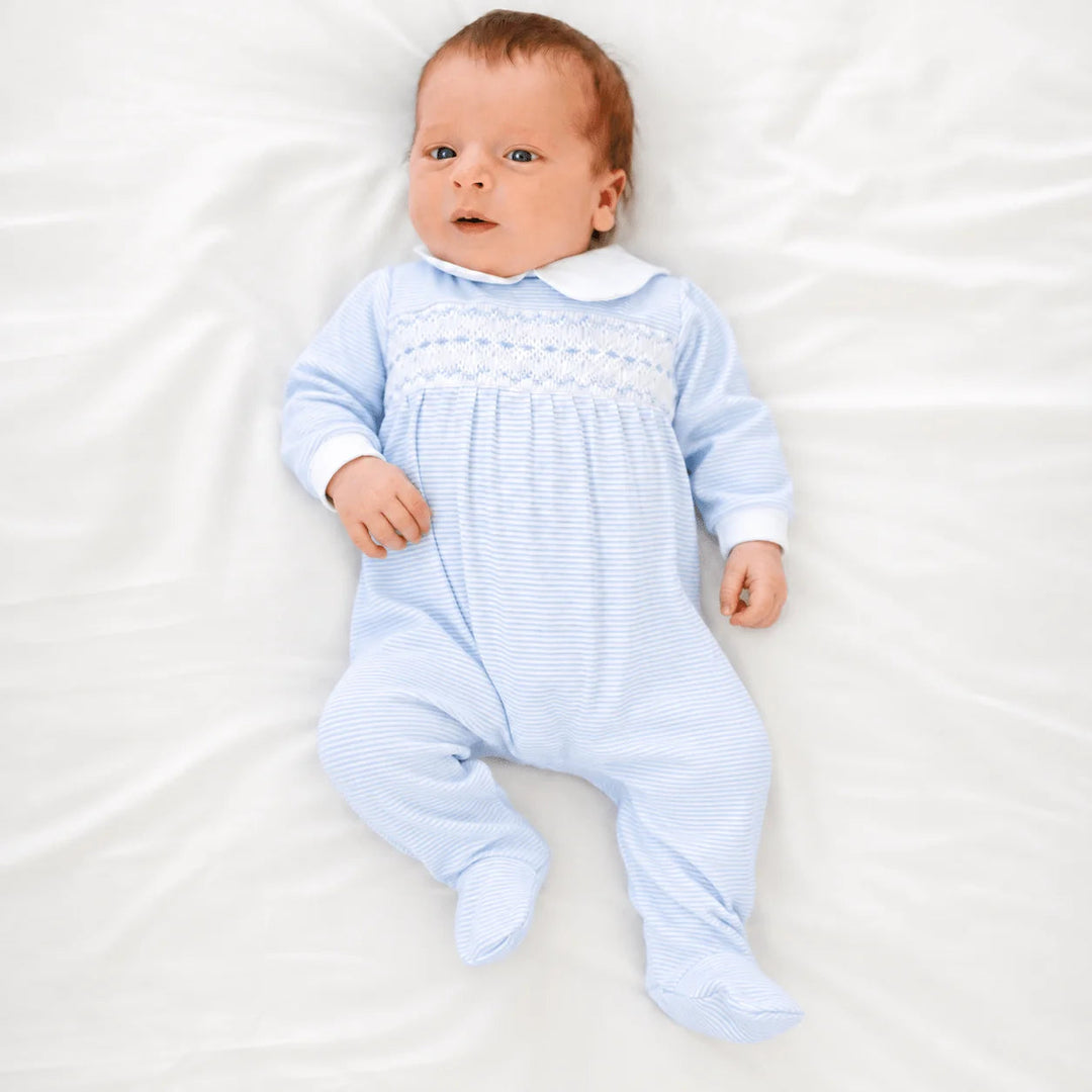 Baby wearing a That Store light blue and white striped Pima cotton footie with hand-smocking and Peter Pan collar.
