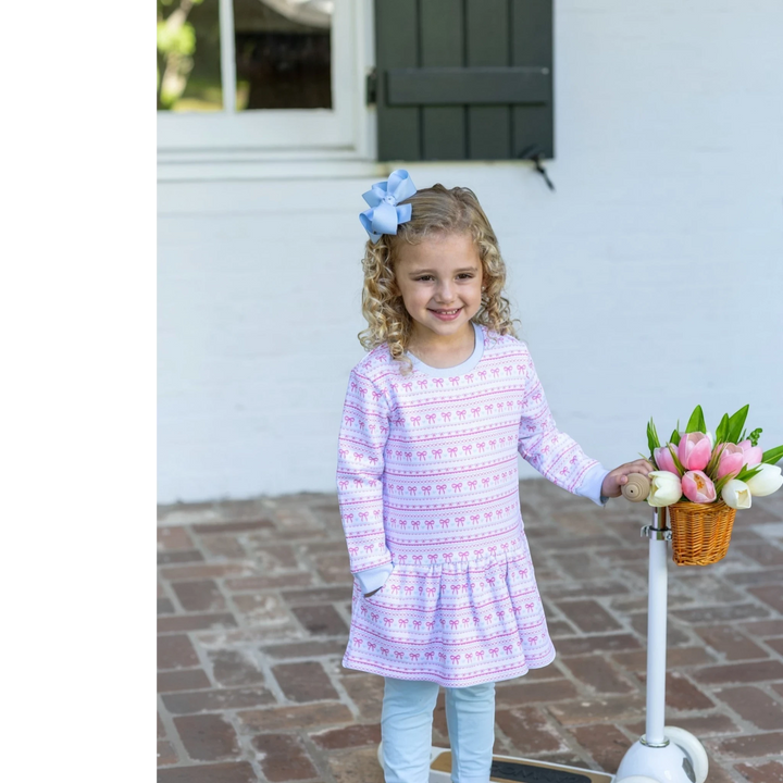 That Store sweetheart French terry tunic set with pink bow print on a girl with a blue hair bow and scooter