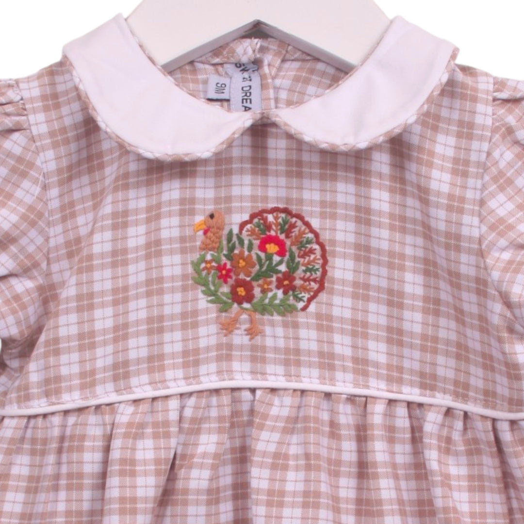 That Store girls beige plaid bubble featuring a white Peter Pan collar and a festive turkey embroidery on the bodice.