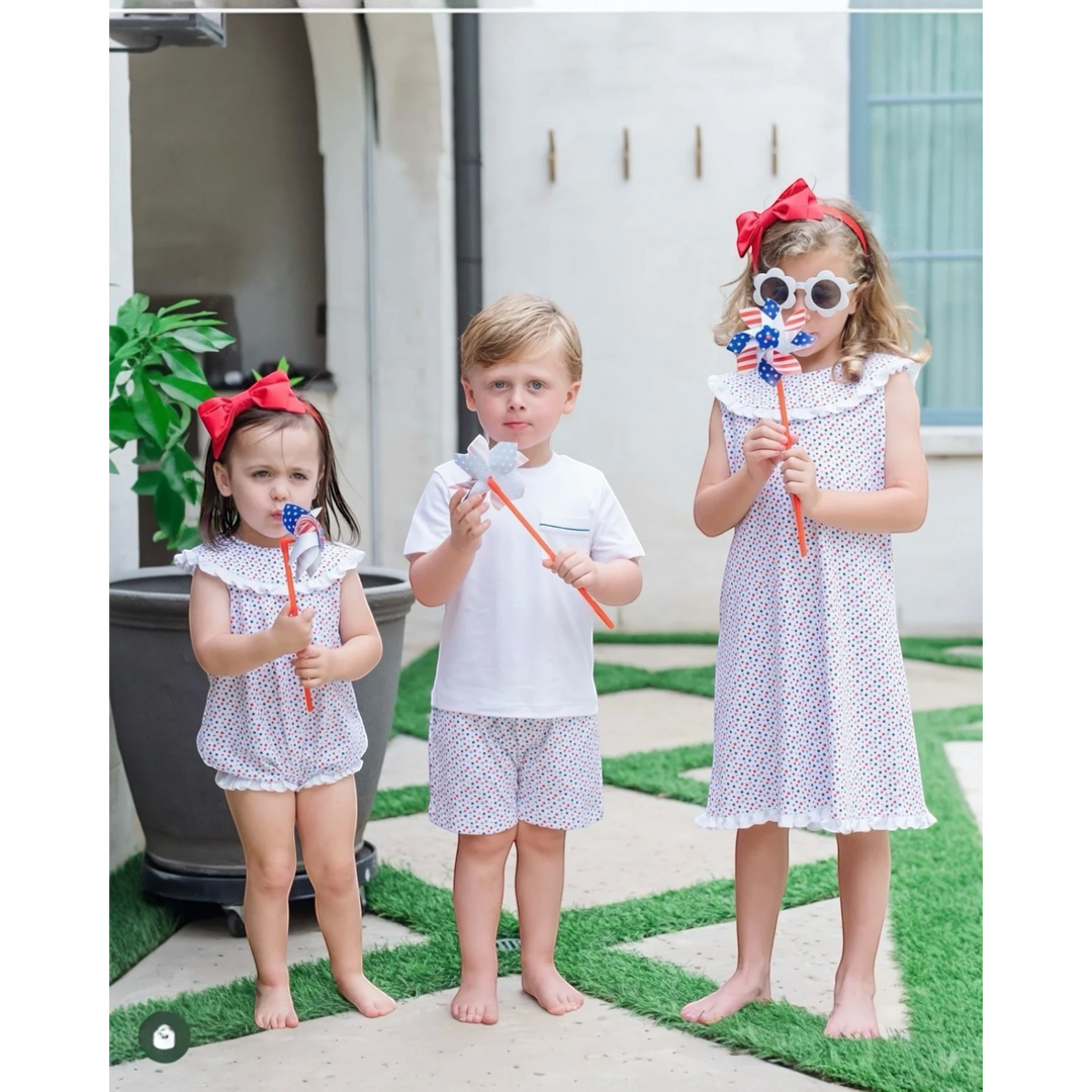 That Store Walker boys short set in white Pima cotton with star spangled print, worn by a boy holding a pinwheel