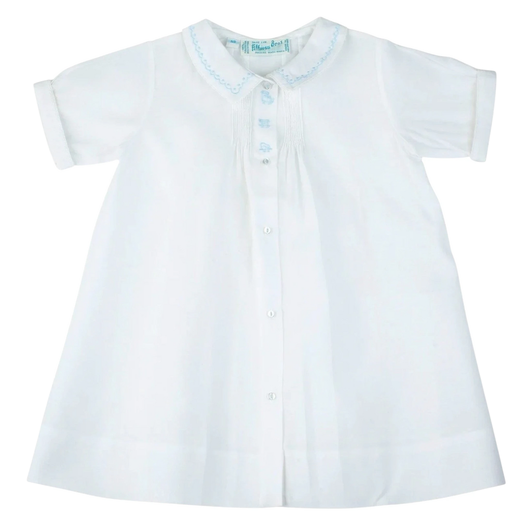 That Store white baby boy daygown with blue train embroidery, pintuck details, and a peter pan collar.